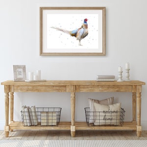 May include: A watercolor painting of a pheasant with a blue and red head and a brown, white, and gray body. The pheasant is standing on a white background with blue dots.