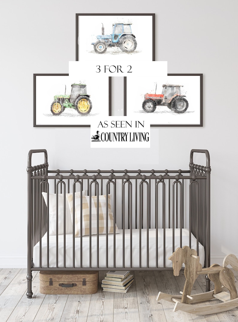 K&ouml;nnte beinhalten: Drei Aquarellbilder von Traktoren in verschiedenen Farben, darunter Blau, Gr&uuml;n und Rot. Die Bilder sind gerahmt und an einer wei&szlig;en Wand &uuml;ber einem grauen Metallkinderbett aufgeh&auml;ngt. Der Text "3 FOR 2" und "AS SEEN IN COUNTRY LIVING" ist im Bild sichtbar.