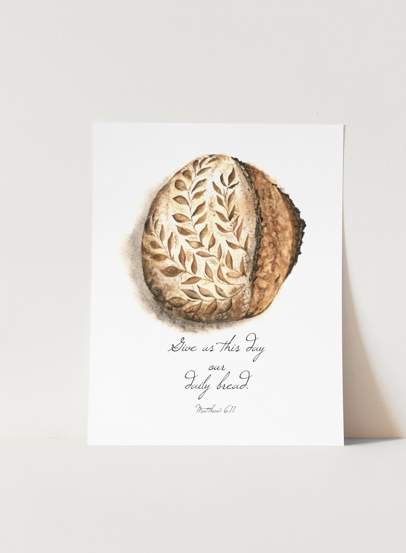 May include: A watercolor painting of a loaf of bread with a leafy design. The text "Give us this day our daily bread. Matthew 6:11" is written below the bread.