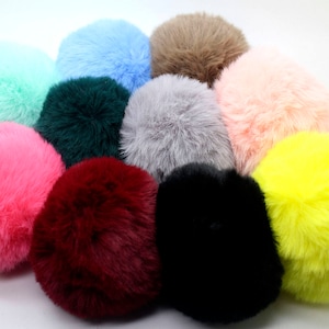 May include: Assortment of ten fluffy pom pom keychains in various colors, including pink, blue, green, yellow, brown, gray, black, and red.