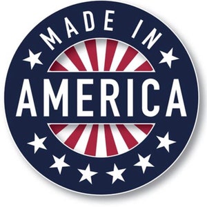 May include: A round sticker with the words "MADE IN AMERICA" in white, arched around the top of the circle. The word "AMERICA" is in large white letters in the center. The background features a blue ring with white stars and red and white stripes.