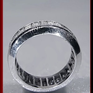Pu&ograve; includere: Un anello a fascia d'argento con una fila di piccoli diamanti quadrati incastonati a canale.