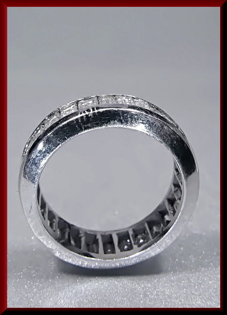 Pu&ograve; includere: Un anello a fascia d'argento con una fila di piccoli diamanti quadrati incastonati a canale.