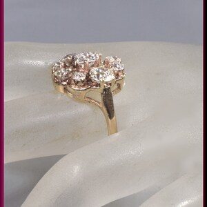 May include: A gold ring with a cluster of small diamonds set in a floral design.