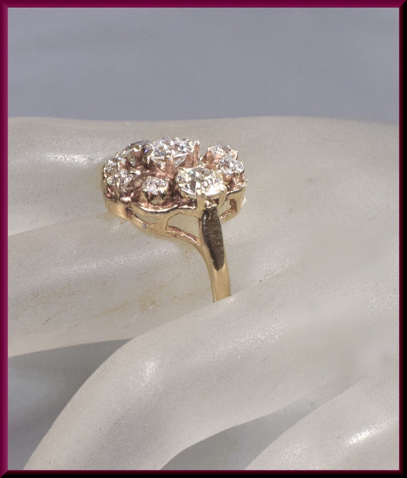 May include: A gold ring with a cluster of small diamonds set in a floral design.