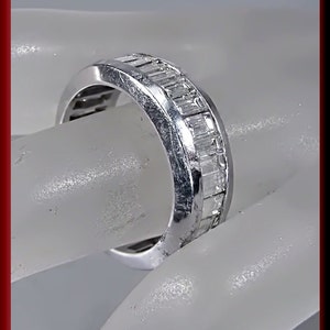 Pu&ograve; includere: Un anello a fascia d'argento con una fila di diamanti a baguette incastonati nella fascia.