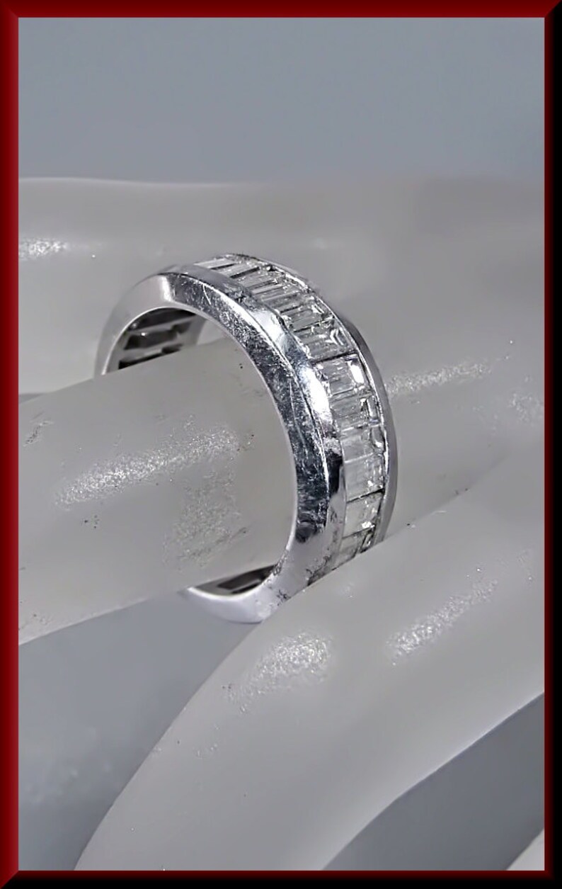 Pu&ograve; includere: Un anello a fascia d'argento con una fila di diamanti a baguette incastonati nella fascia.