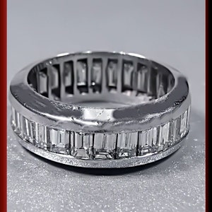 Pu&ograve; includere: Un anello a fascia d'argento con una fila di diamanti a baguette incastonati a canale.