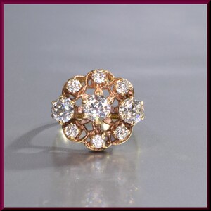 May include: A gold ring with a floral design set with diamonds.