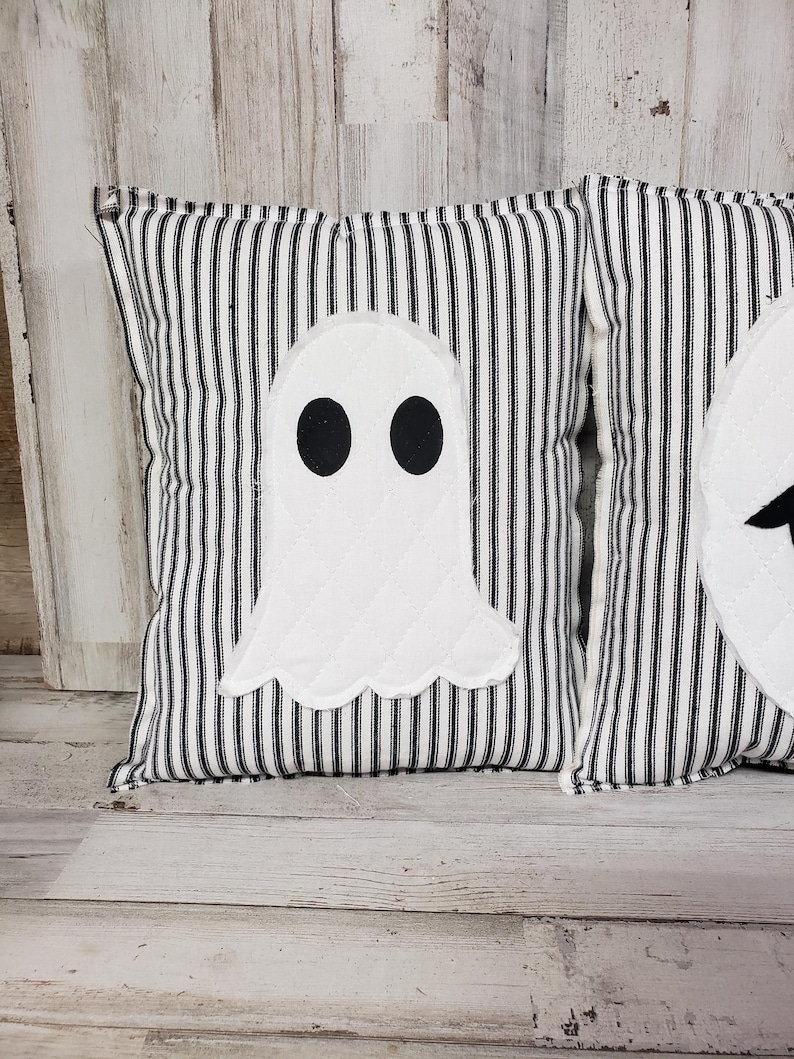 May include: Two black and white striped pillow covers with white ghost appliques. The ghosts have black eyes.