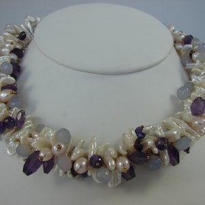 Profusion of pearls, purple amethyst and pale, purple hued chalcedony on vermeil pins are tightly clustered in powerful choker-style design