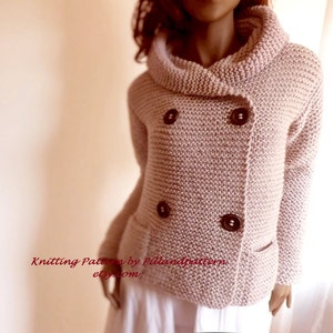 May include: A pink knitted cardigan with a double breasted closure and a large collar. The cardigan has two pockets and brown buttons.