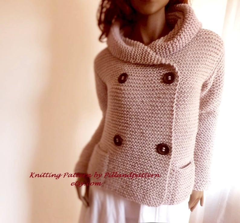 May include: A pink knitted cardigan with a double breasted closure and a large collar. The cardigan has two pockets and brown buttons.