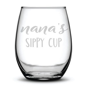 May include: A clear glass wine glass with the text "nana's sippy cup" etched on the front.