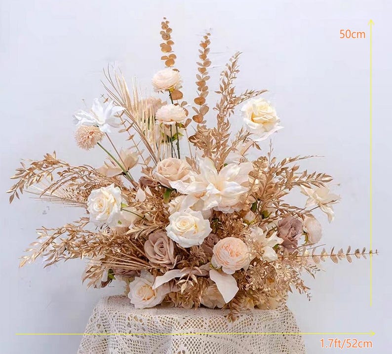 May include: A large, cream-colored floral arrangement with dried grasses and pampas grass. The arrangement is 50 cm tall and 52 cm wide.