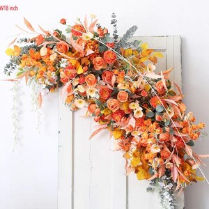 May include: A floral garland with orange and yellow flowers and greenery. The garland is 60 inches long and 18 inches wide.