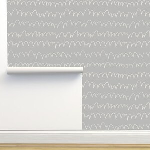 May include: A roll of gray wallpaper with a white, hand-drawn wavy pattern.