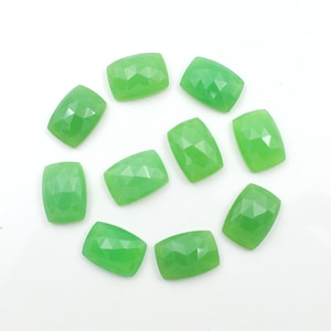 May include: Ten green gemstone cabochons in a rectangular shape with faceted edges. The stones are arranged in a circle on a white background.