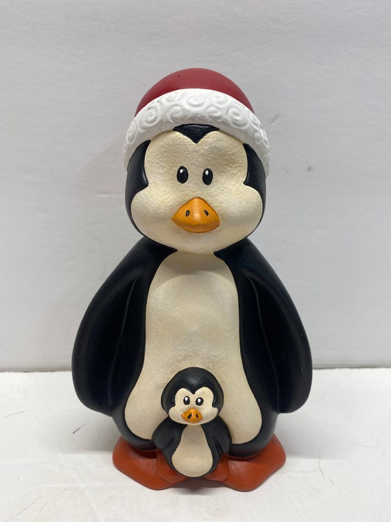 Adorable cartoon penguin wearing a blue hat and scarf, holding a camera, ready to capture winter