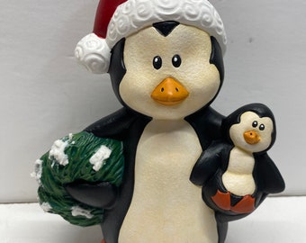 Handmade, one-of-a-kind, 7” tall Christmas penguin with a baby penguin and holding a Christmas tree.