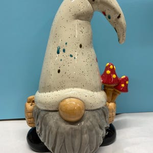 One of a kind glazed handmade ceramic gnome with place in hand to hold flowers or a sign.