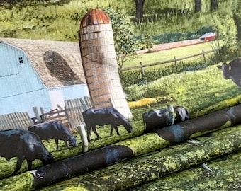 May include: A black and white fabric with a repeating pattern of cows and a red barn in a green field. The fabric is folded in thirds, showing the pattern on each fold.