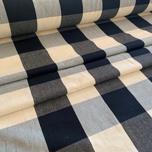 May include: Black and white buffalo check fabric. The fabric has a woven texture and is folded in thirds.