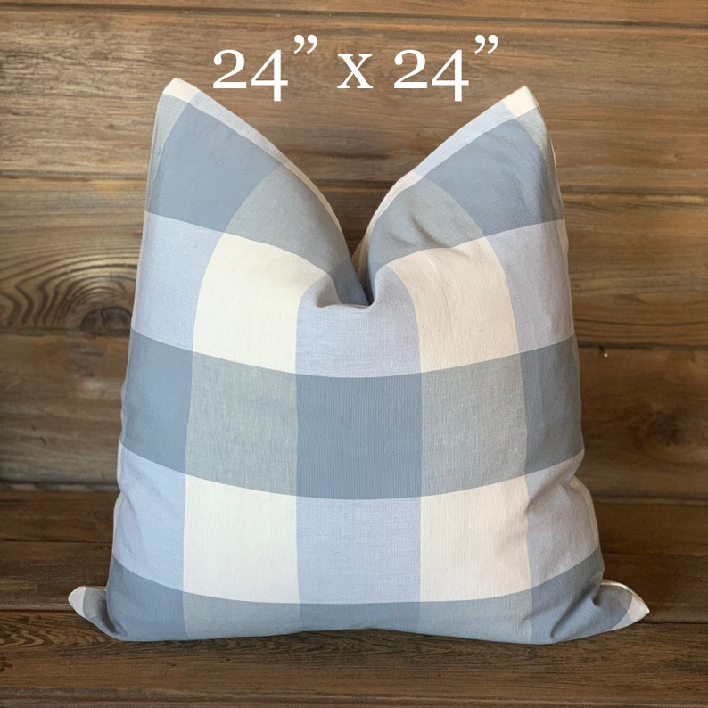 May include: A 24" x 24" blue and white gingham pillow cover. The pillow cover is made of a soft, woven fabric and has a subtle sheen.