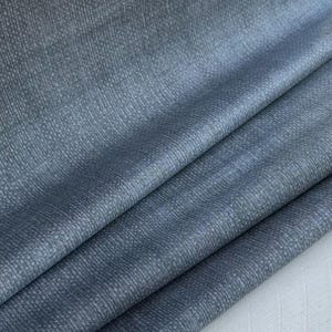 Puede incluir: Primer plano de una tela azul con un patrón texturizado y tejido. La tela tiene un brillo sutil y una sensación suave y lisa.