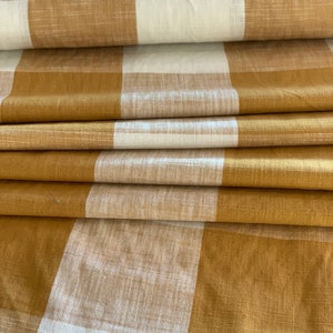 May include: A folded piece of fabric with a brown and white checkered pattern. The fabric is soft and has a subtle texture.