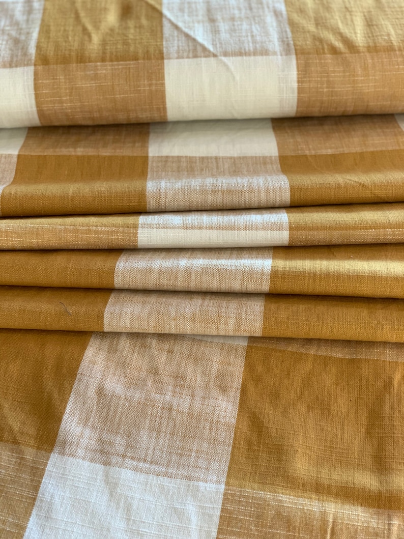 May include: A folded piece of fabric with a brown and white checkered pattern. The fabric is soft and has a subtle texture.