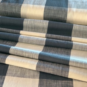 May include: A folded piece of fabric with a black and white checkered pattern. The fabric has a textured, woven look.