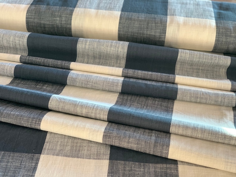 May include: A folded piece of fabric with a black and white checkered pattern. The fabric has a textured, woven look.