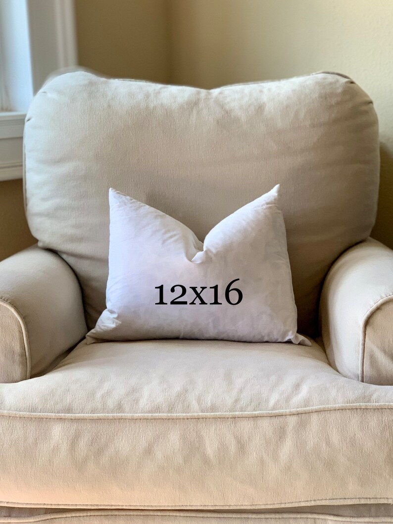 May include: A white pillow with the text "12x16" printed on it, sitting on a beige armchair.