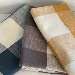 May include: Three fabric swatches with a checkered pattern. The swatches are in black and white, brown and white, and yellow and white.