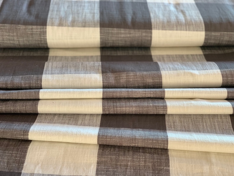 May include: Brown and white checkered fabric with a textured weave. The fabric is folded in thirds, showing the pattern.