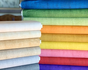 Puede incluir: Un conjunto de 15 muestras de tela en varios colores, incluyendo turquesa, azul, verde, amarillo, naranja, rosa, rojo, morado, gris y beige. La tela tiene una textura sutil.
