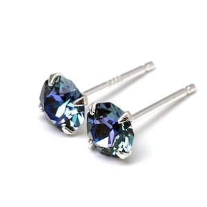 Puede incluir: Un par de pendientes de plata con piedras preciosas iridiscentes azules y verdes.