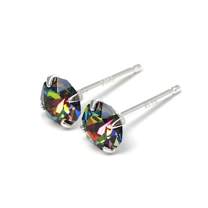 May include: A pair of stud earrings with iridescent, multi-colored round crystals set in silver-toned metal. The earrings are displayed on a white background. The brand name "Studemann" is visible in the bottom right corner.