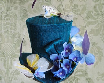 Mini sombrero de copa color turquesa con flores y mariposas, ideal para bodas de primavera. Listo para enviar.