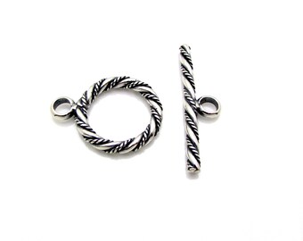 May include: Silver-toned twisted rope toggle clasp with a round ring and a straight bar. The clasp is designed for jewelry making.