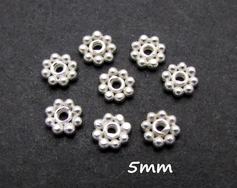 Puede incluir: Ocho cuentas espaciadoras de plata con diseño de flor. Cada cuenta tiene un diámetro de 5 mm.