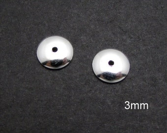 May include: Two silver-toned metal bead caps with a small hole in the center. The caps are 3mm in diameter.