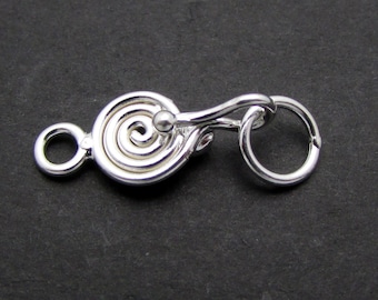 May include: Silver-toned clasp with a spiral design and a small ball accent. The clasp has a loop on one end and a hook on the other.