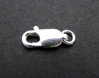 Puede incluir: Cierre de langosta plateado con un anillo redondo. Este cierre se utiliza para la fabricación de joyas y es un tipo de cierre común para collares y pulseras.