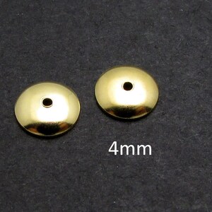 May include: Two gold-colored metal bead caps with a small hole in the center. The bead caps are 4mm in diameter.