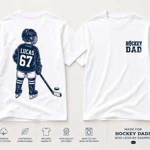 May include: White t-shirts with navy blue graphics. One shirt features a hockey player with the name "LUCAS" and the number "67". The other shirt has "HOCKEY DAD" printed on the front. The shirts are made of premium soft cotton.