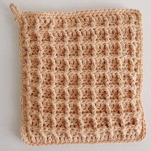 May include: A beige crocheted pot holder with a waffle stitch pattern.