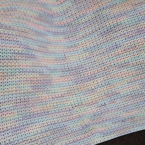 May include: A soft, crocheted baby blanket in a pastel color scheme with shades of pink, blue, and green.