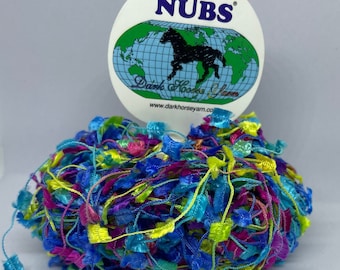 Puede incluir: Una bola de hilo de colores con una etiqueta que dice "NUBS" Dark Horse Yarn www.darkhorseyarn.co